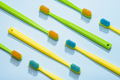Different colors toothbrushes, green and yellow on a blue background. - PhotoDune Item for Sale