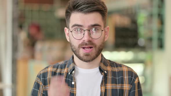 Portrait of Young Man Pointing at the Camera with Finger