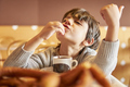 elementary age kid boy enjoying yummy churros into a hot chocolate mug - PhotoDune Item for Sale