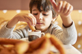 elementary age kid dipping churros into a hot chocolate mug - PhotoDune Item for Sale