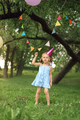 A funny birthday girl in a blue dress and a pink festive cap - PhotoDune Item for Sale