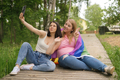 LGBT female couple takes selfie on smartphone making a hand greeting gesture. - PhotoDune Item for Sale
