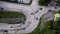 Aerial view of the concrete road leading to the industrial zone. Clip. Cars driving near green - PhotoDune Item for Sale
