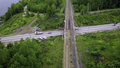 Aerial view of the concrete road leading to the industrial zone. Clip. Cars driving near green - PhotoDune Item for Sale