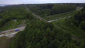 Road next to forest and river. Drone view. Clip.Dirty meandering river in the forest next to tall - PhotoDune Item for Sale