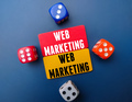 Colored board and dice with the word WEB MARKETING. Business concept - PhotoDune Item for Sale
