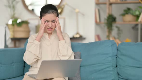 Indian Woman with Laptop Having Headache on Sofa