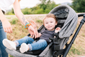 Mother next to a kid sitting in a baby carriage - PhotoDune Item for Sale