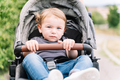 Portrait of a small kid sitting inside a baby carriage - PhotoDune Item for Sale