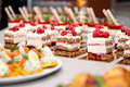Close up of cakes with fresh fruits and berries arranged in a row on a party table - PhotoDune Item for Sale