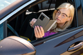 a middle aged blonde woman in glasses with a smartphone looks through an open car window - PhotoDune Item for Sale