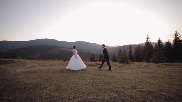 Newlyweds. Caucasian Groom with Bride on Mountain Slope. Groom Proposes