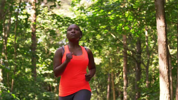 Young African American Woman Running in Forest