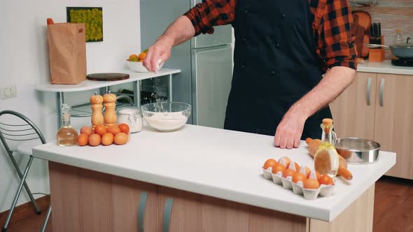 Senior Man Taking Flour From Glass Bowl