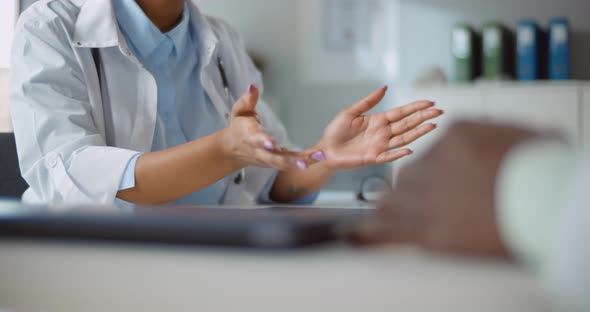 Cropped Shot of African Doctor Talking to Patient in Clinic Office