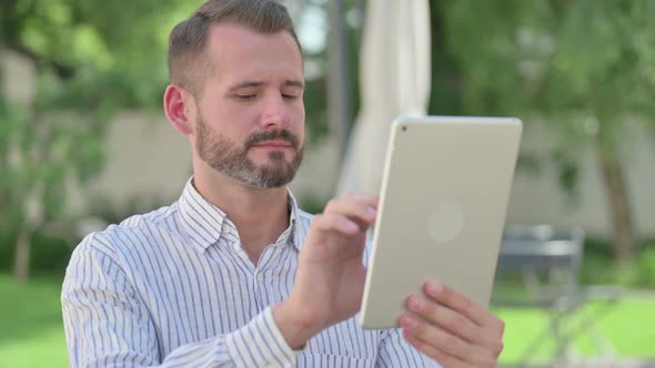 Outdoor Portrait of Middle Aged Man Using Tablet