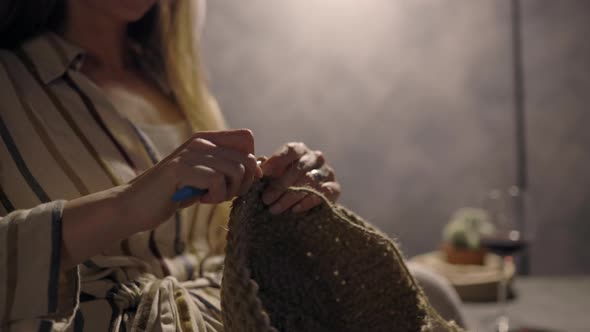 Close Up Woman Handcrafting at Home, Crocheting with Knitting Needles a Home Basket Decor