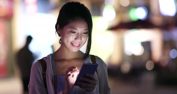 Woman use of cellphone in city in the evening