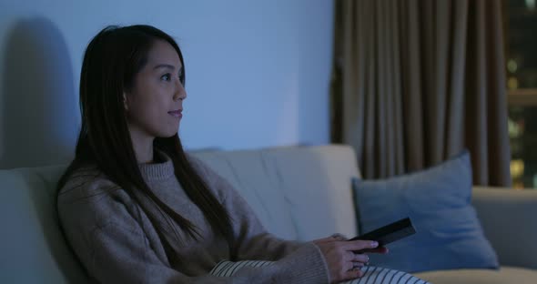 Woman watch tv at home in the evening