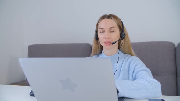Friendly online support operator speaking in headset microphone on web camera in 4k video