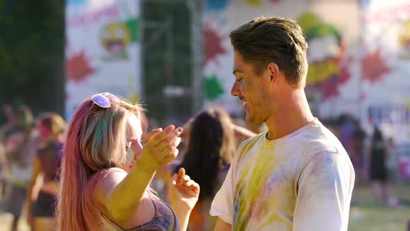 Young Attractive Couple Dancing in a Colorful Dust at Traditional Holi Fest