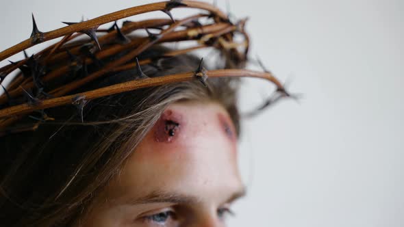 Jesus in a Crown of Thorns with Wounds on Face on a White Background