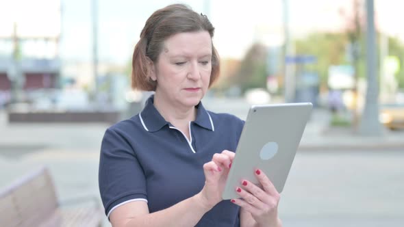 Upset Old Woman Reacting to Loss on Tablet Outdoor