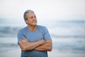 Cheerful retired man with crossed arms by the sea - PhotoDune Item for Sale