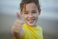 Outdoor portrait of a happy boy with thumbs-up - PhotoDune Item for Sale