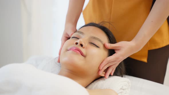 Asian young woman feel happy and relax during facial and head massage.