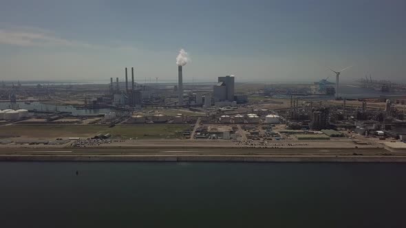 Tower with smoke in industrial harbor of Rotterdam in the Netherlands, Aerial