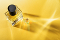Transparent bottle of perfume on a yellow background with sun light rays. - PhotoDune Item for Sale