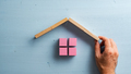 Male hand building a house of pink wooden blocks - PhotoDune Item for Sale