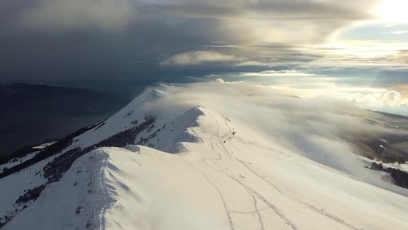 Drone fly over the Snow Mountains peak at sunset