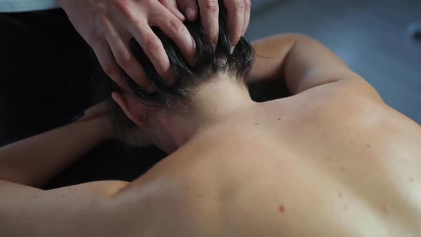 Masseur Man Makes a Head Massage for a Woman.