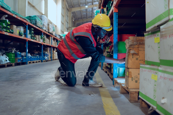 Warehouse worker in a large warehouse searching for small items in the shelf