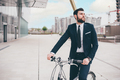 Elegant bearded young stylish businessman going to work by bike - PhotoDune Item for Sale