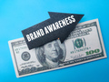 Arrow wooden board with the word BRAND AWARENESS on a banknotes. Business concept. - PhotoDune Item for Sale