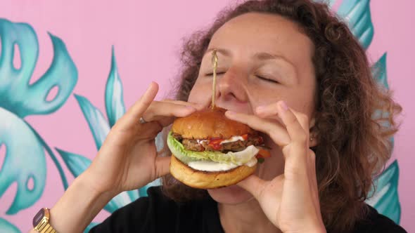 Very Hungry Young Woman Eats Her Vegan Burger with Great Pleasure and Joy