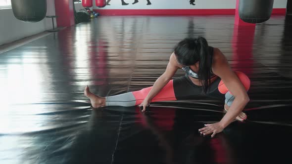 Determined Sporty Caucasian Woman Working Out Doing Stretching Exercise on the Gymnastic Mat