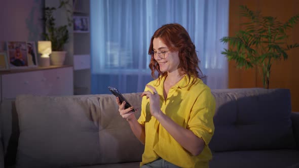 Female Shopper with Eyeglasses Orders Groceries in Store Online on Smartphone While Sitting at Home