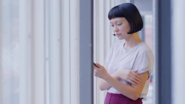 Female creative using smartphone in a modern office