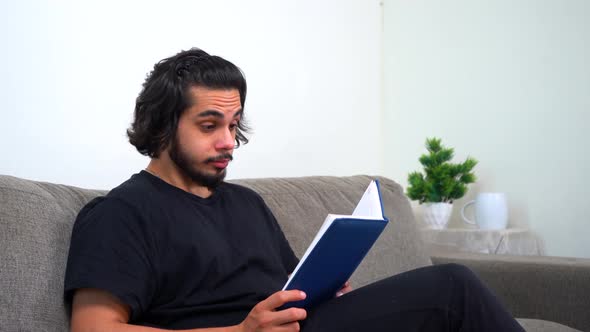 Tired Indian man reading book late at night