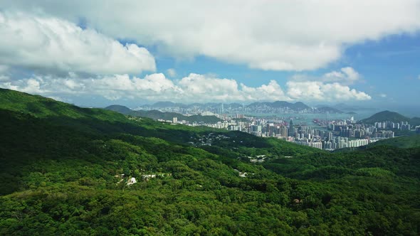 A dynamic high altitude aerial footage revealing the cityscape of Hong Kong surrounded by trees, the