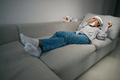 Sick woman lies on the couch with a runny nose - PhotoDune Item for Sale