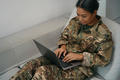 Cute female soldier is typing something in a laptop - PhotoDune Item for Sale