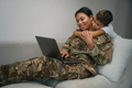 Female military is located with laptop at home on couch - PhotoDune Item for Sale