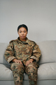 Woman in camouflage clothes sits on a soft sofa - PhotoDune Item for Sale