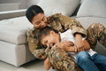Woman soldier and boy play and laugh in the room - PhotoDune Item for Sale