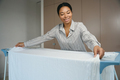 African american woman hangs laundry to dry in bright room - PhotoDune Item for Sale